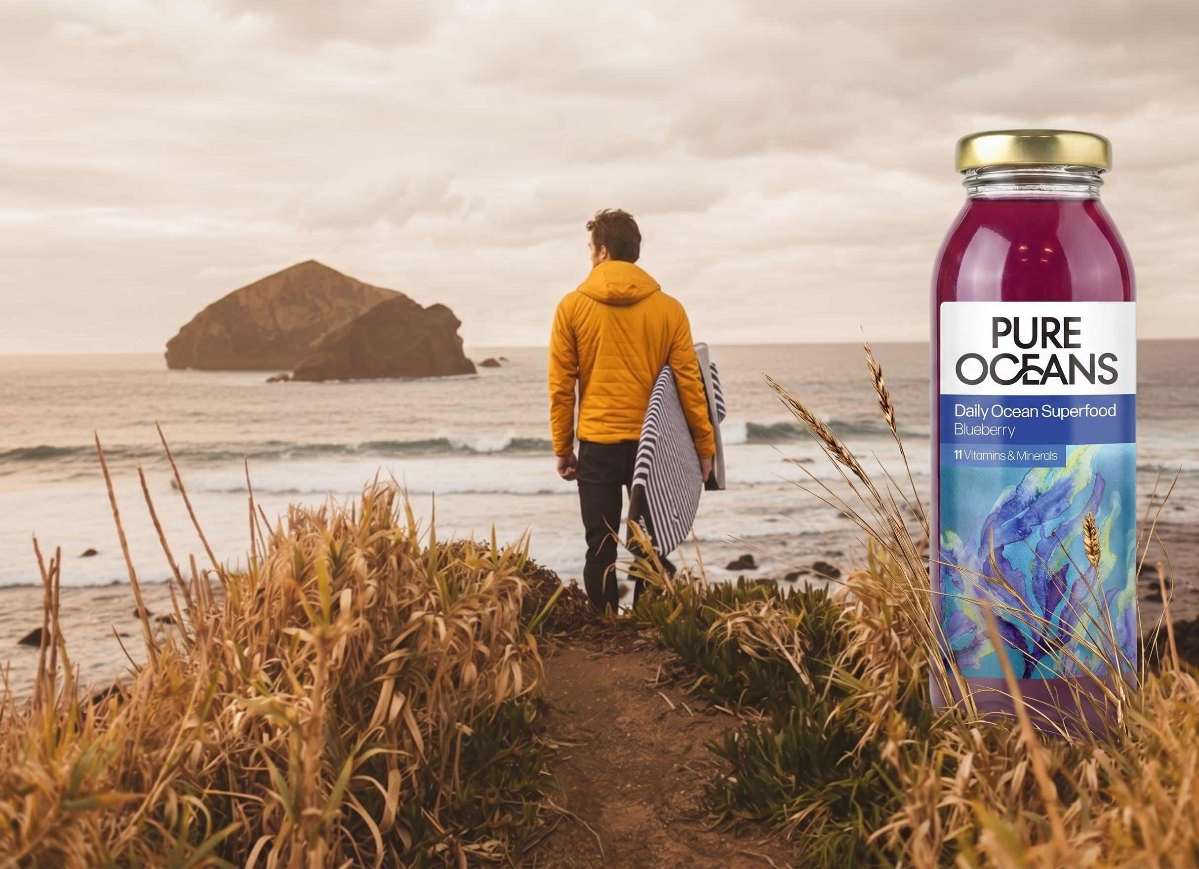 A lone figure walks toward the surf at first light, a bottle of Pure Oceans in the golden coastal grass